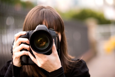 Woman taking a photo in the city during the day with bokeh background