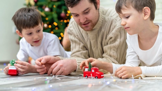 Dad with sons playing on the floor.