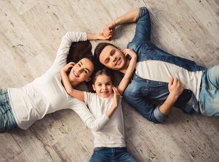 man, woman, & daughter laying on the ground to symbolize a family in NYC