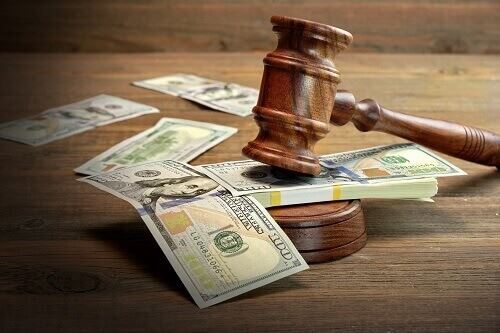 A judges gavel over a bundle of cash symbolizing equitable distribution.